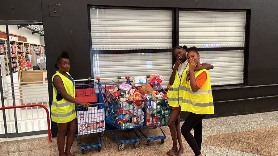 Jeunes bénévoles du Secours Adventiste avec caddies de denrées